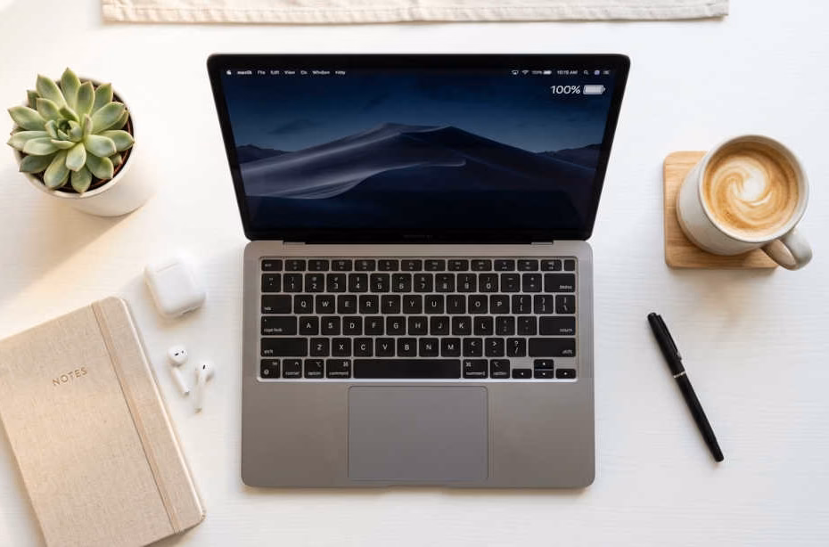 Laptops con mayor duración de batería: laptop ultradelgada con batería completa sobre escritorio minimalista