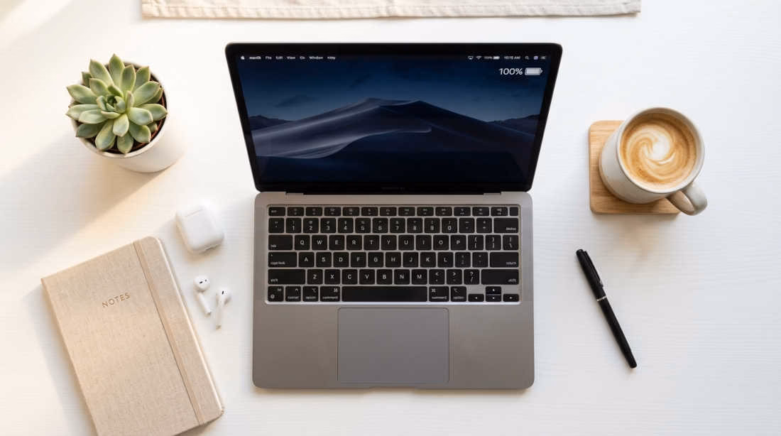 Laptops con mayor duración de batería: laptop ultradelgada con batería completa sobre escritorio minimalista