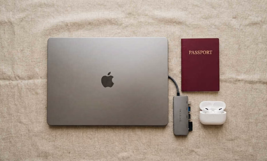 Laptops ligeras para viajar: laptop ultraligera junto a pasaporte y accesorios compactos