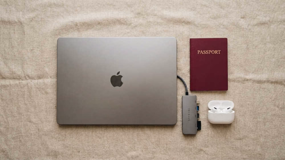 Laptops ligeras para viajar: laptop ultraligera junto a pasaporte y accesorios compactos