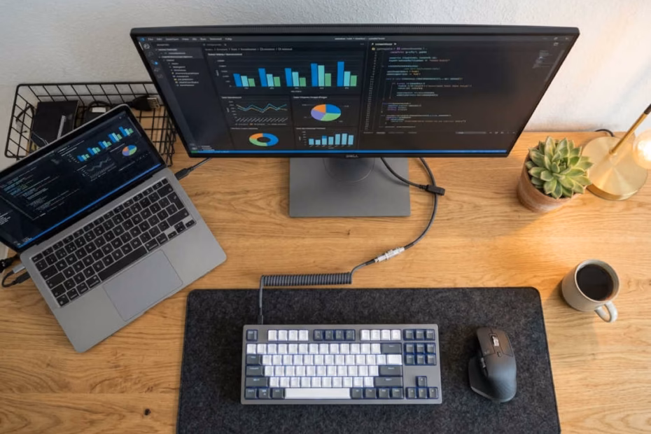 Setup de escritorio para trabajar desde casa: Setup de escritorio minimalista para trabajo desde casa con monitor externo, teclado mecánico y laptop